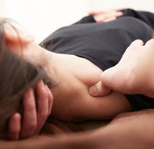 A Japanese woman getting a shoulder massage